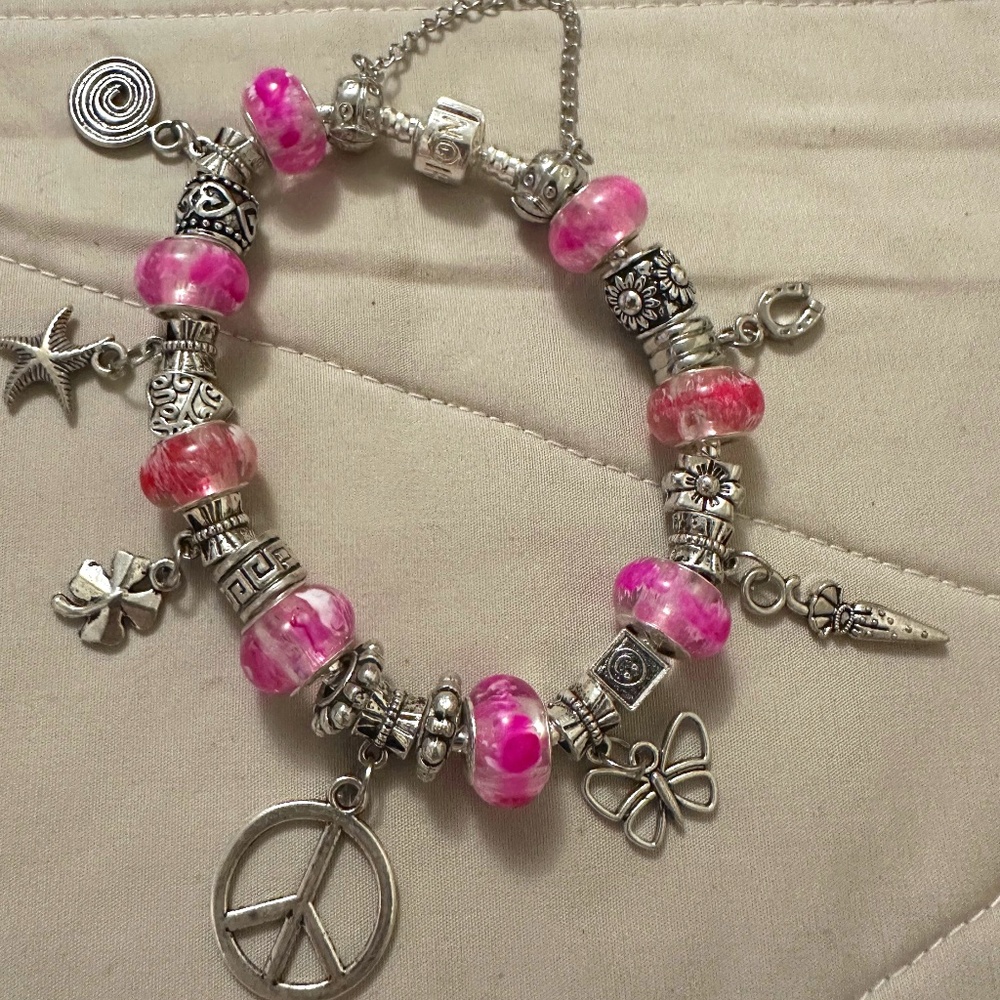 Handmade – NWOT – 925 SS plated charm bracelet. 8 Pink beads, charm variety.